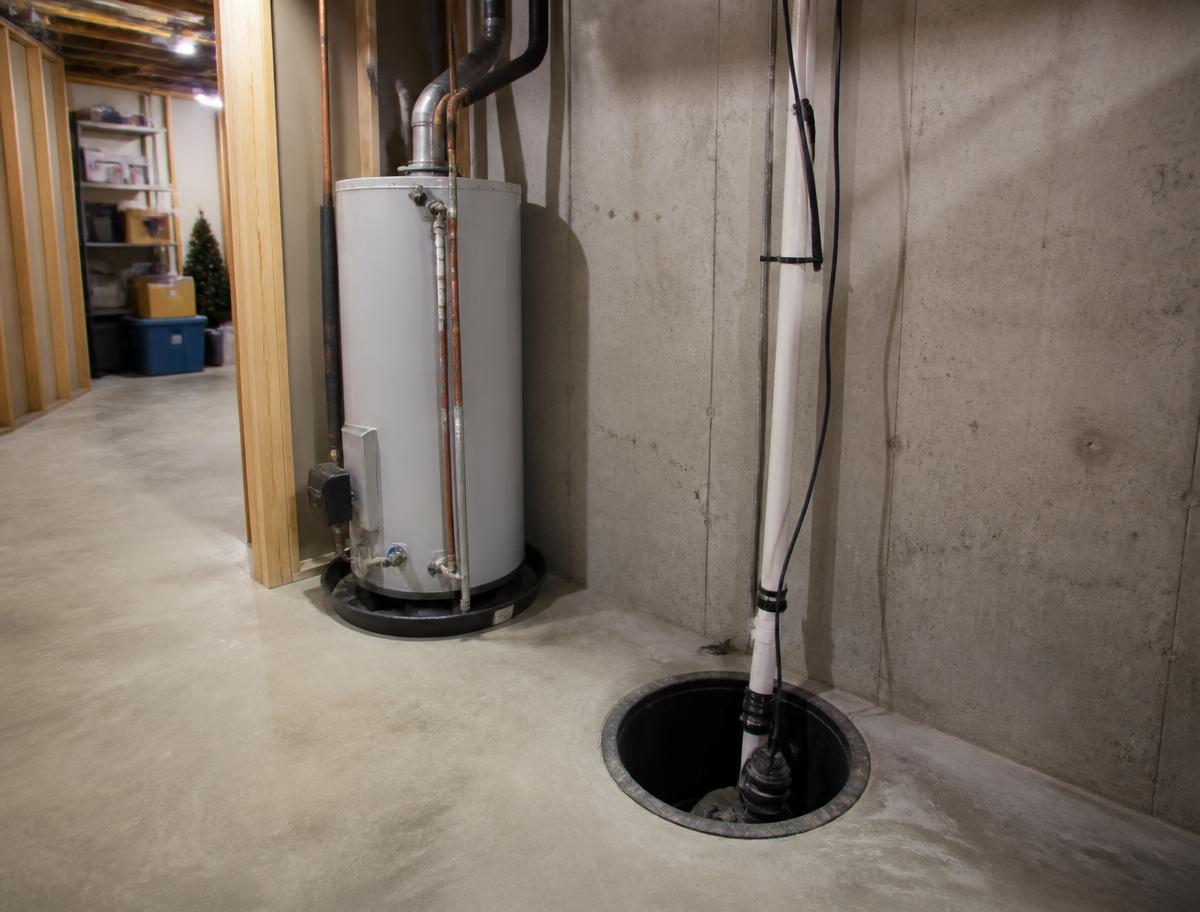Residential basement with a water heater and sump pump pit